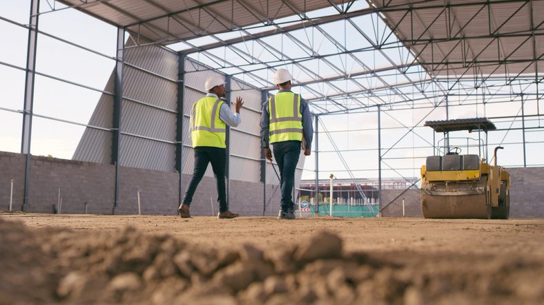 Engineering, cooperation and men on construction site planning and project management. Contractor team in warehouse, b2b in industrial service and work in building development. Engineering, cooperation and men on construction site planning and project management. Contractor team in warehouse, b2b in industrial service and work in building development.